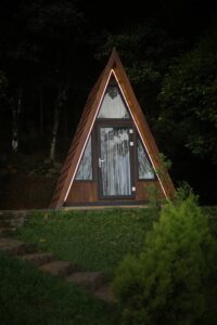 Charming A-Frame Hut at Cloud Cabana Holidays Vagamon offering a snug interior with picturesque views of the Vagamon landscape.
