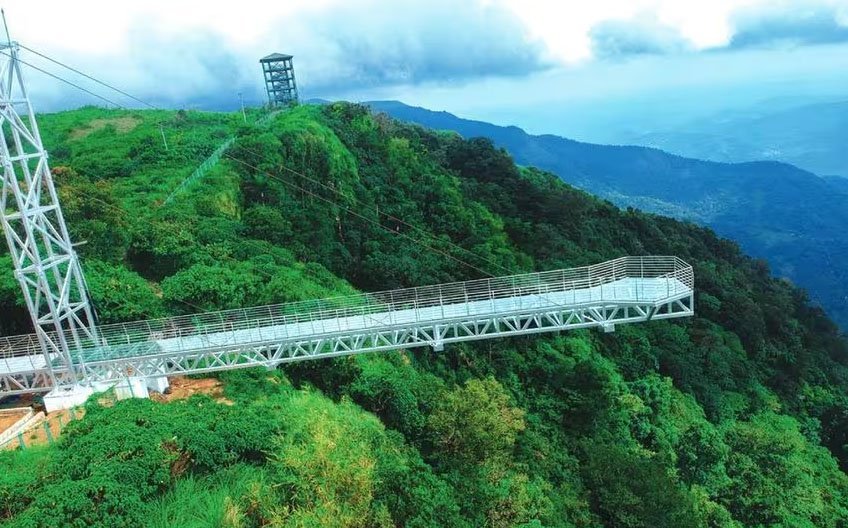 Vagamon Glass Bridge with a transparent floor, offering a thrilling view of the surrounding landscape and valley below.